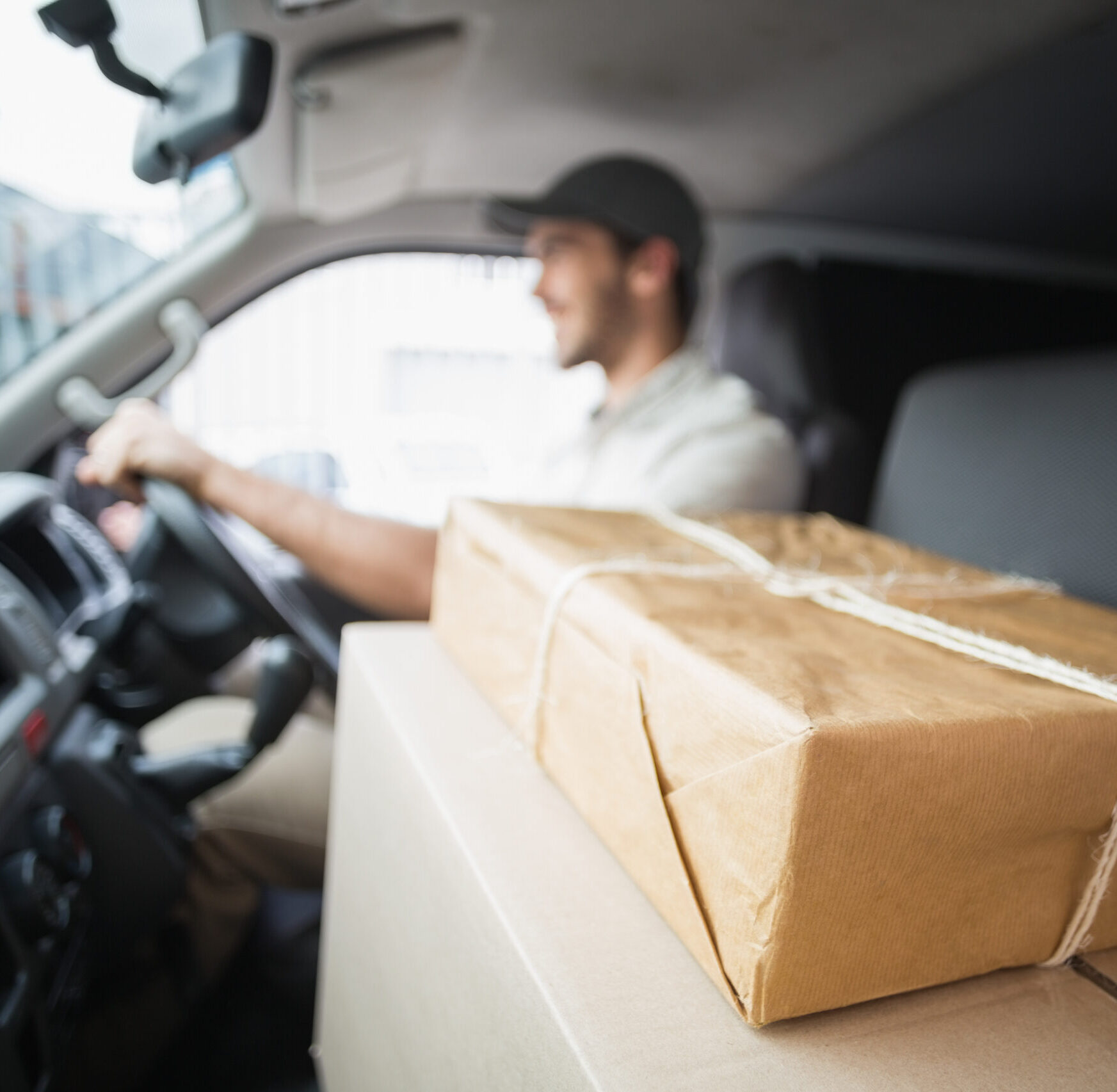 Delivery,Driver,Driving,Van,With,Parcels,On,Seat,Outside,The